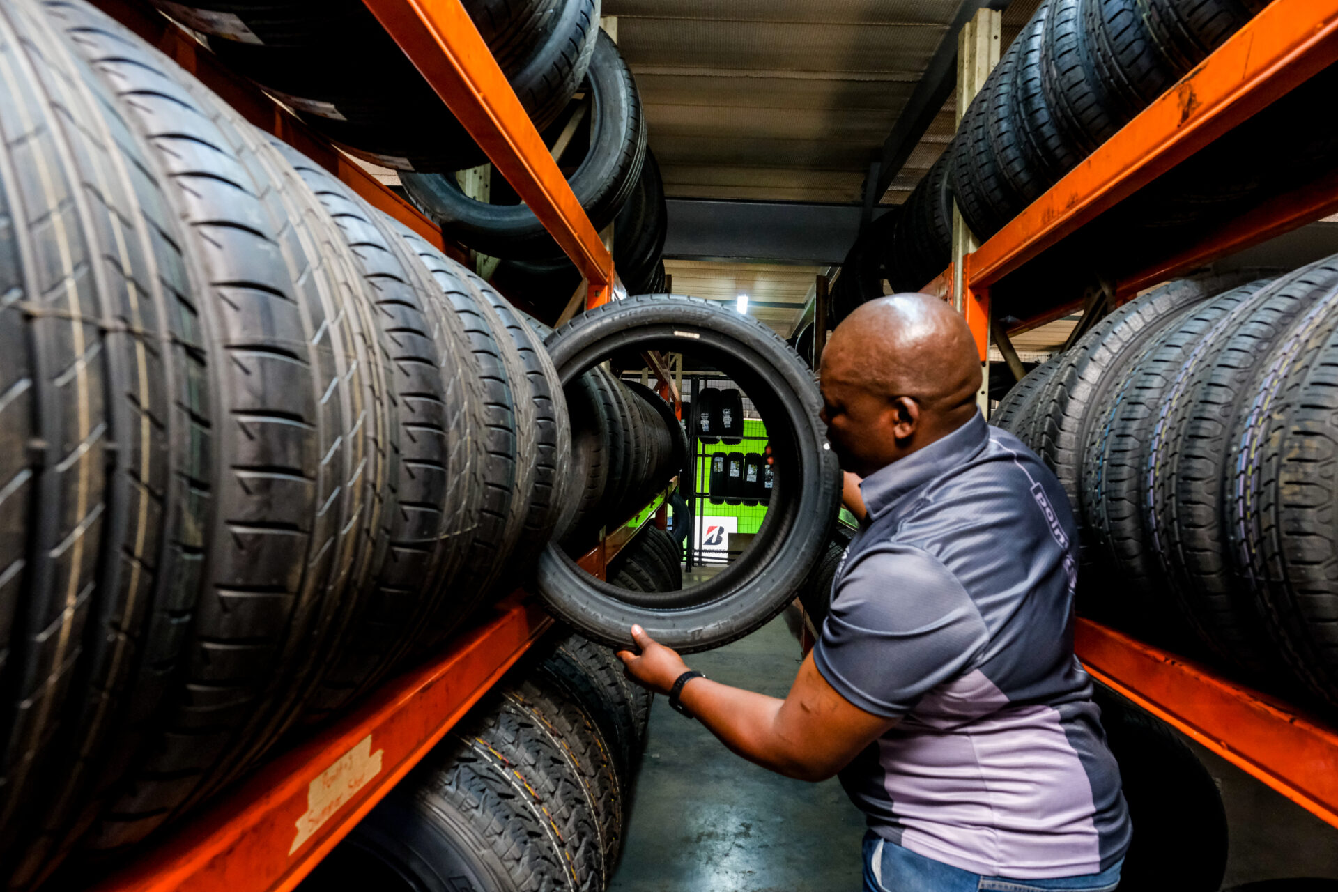An Astro Tyres member organising a tyre shelf.